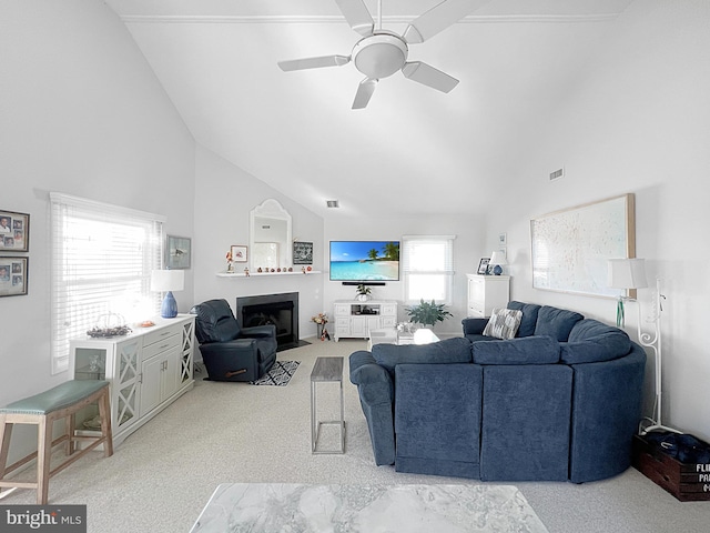 living room with high vaulted ceiling, ceiling fan, light carpet, and a wealth of natural light