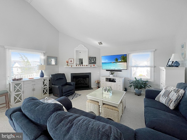 carpeted living room featuring high vaulted ceiling