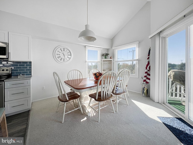 dining area featuring carpet flooring and vaulted ceiling