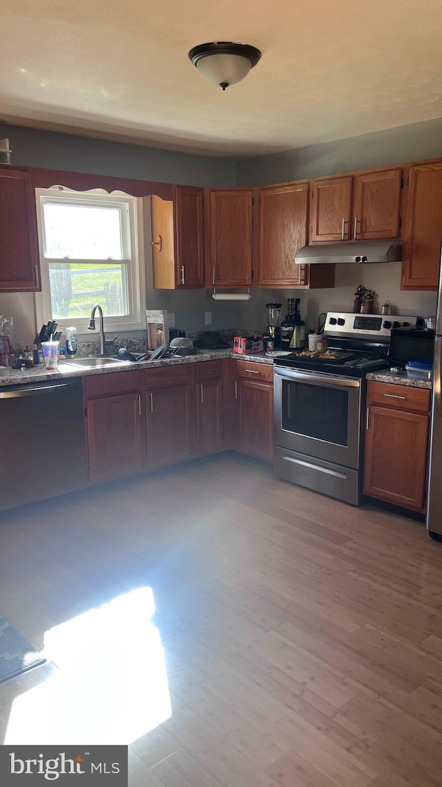 kitchen featuring stainless steel appliances, light hardwood / wood-style flooring, and sink