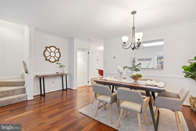 dining room featuring stairs, ornamental molding, dark wood finished floors, and an inviting chandelier