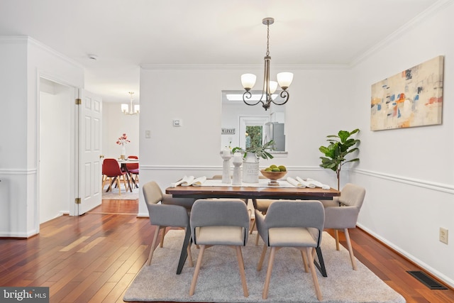 dining space with visible vents, dark wood-type flooring, and a notable chandelier