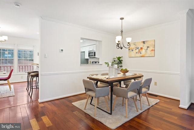 dining area with dark wood-style floors, baseboards, and an inviting chandelier