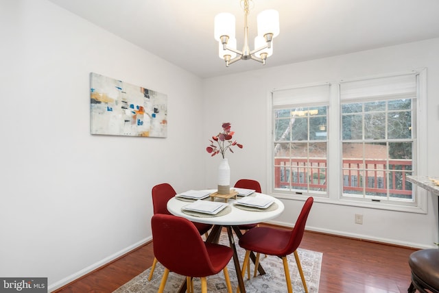 dining room with a notable chandelier, dark wood finished floors, and baseboards