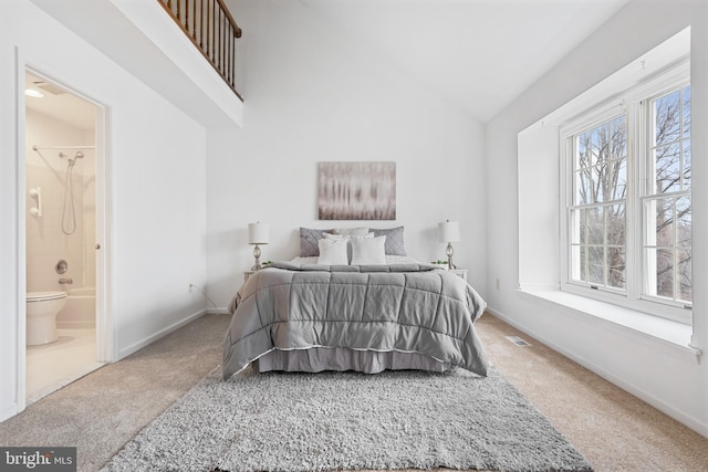 carpeted bedroom featuring lofted ceiling, baseboards, visible vents, and ensuite bathroom