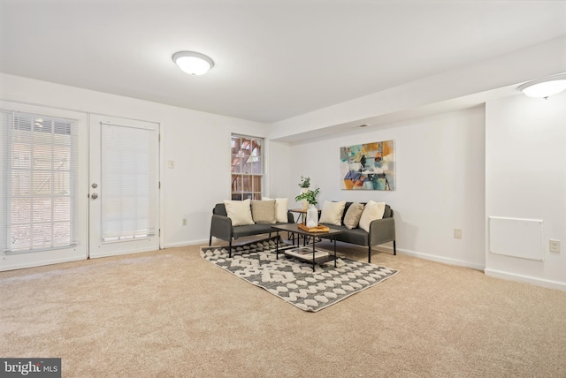 sitting room with a healthy amount of sunlight, baseboards, and light colored carpet