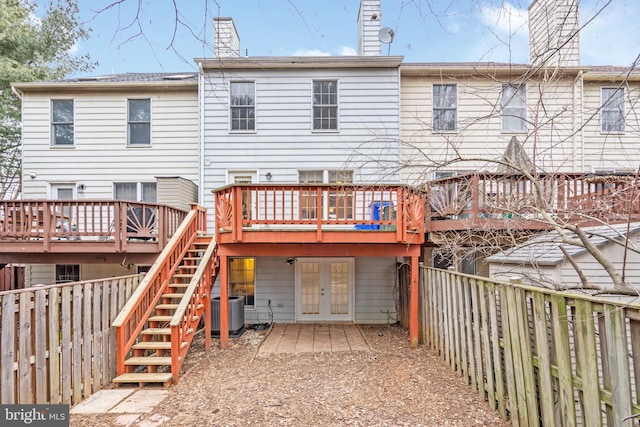 rear view of property with french doors, stairway, central AC unit, a fenced backyard, and a wooden deck