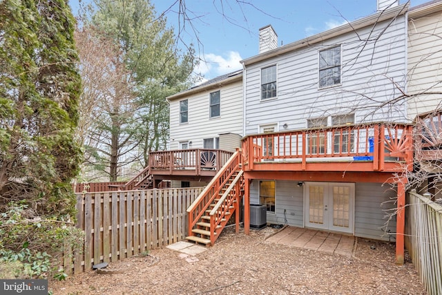 rear view of property featuring a chimney, stairway, a deck, and french doors