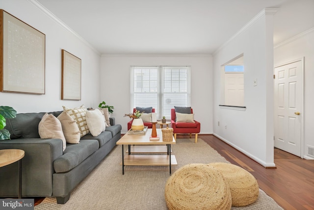 living area featuring ornamental molding, visible vents, baseboards, and wood finished floors