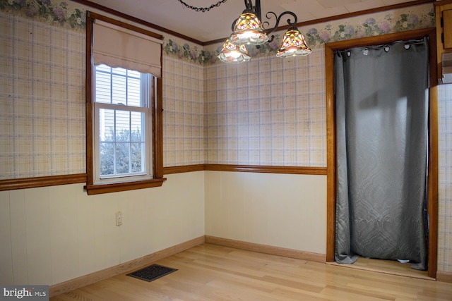 empty room with light wood-type flooring and ornamental molding