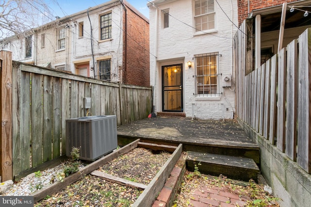 property entrance featuring central AC unit and a wooden deck