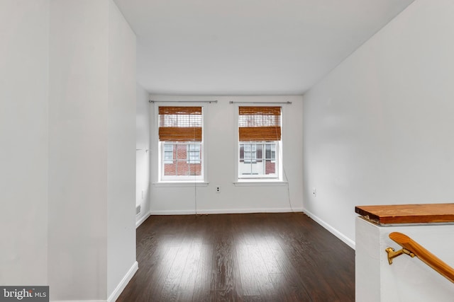 empty room with dark hardwood / wood-style flooring