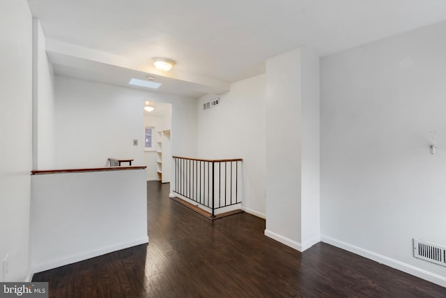 unfurnished room with dark hardwood / wood-style flooring