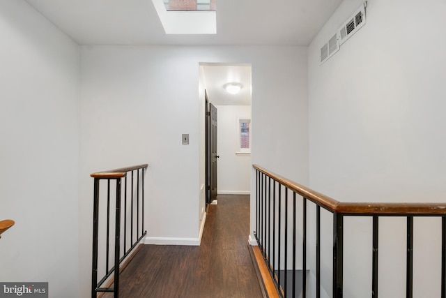 hall with dark hardwood / wood-style floors and a skylight