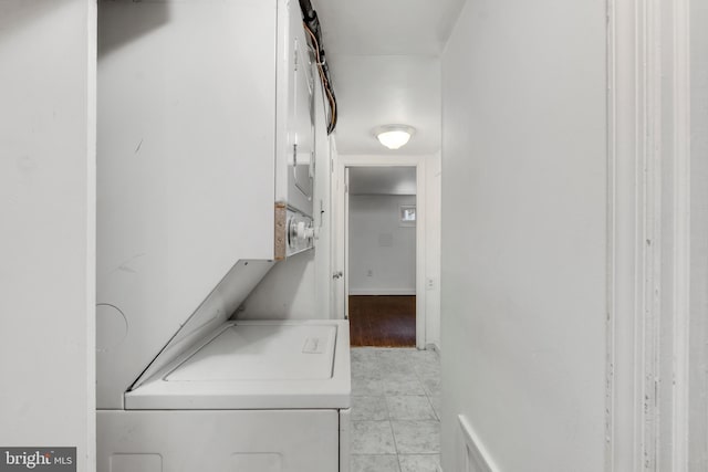 clothes washing area with stacked washer and clothes dryer