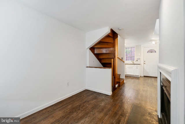 unfurnished living room with dark wood-type flooring