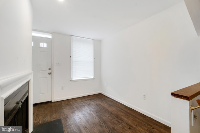 unfurnished living room featuring dark hardwood / wood-style floors and plenty of natural light