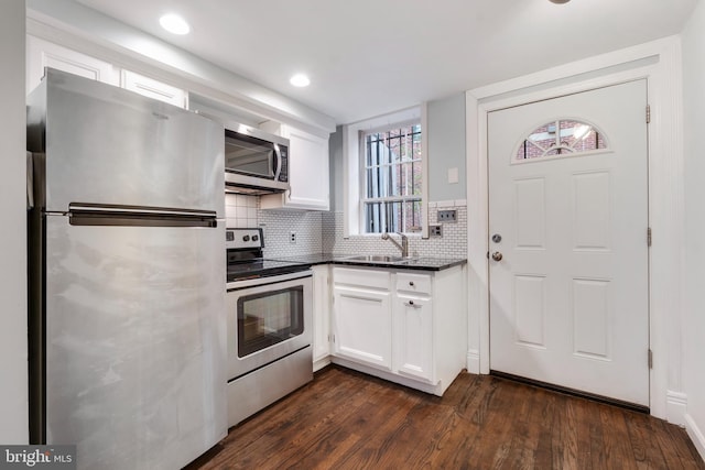 kitchen featuring white cabinets, sink, dark hardwood / wood-style floors, tasteful backsplash, and stainless steel appliances