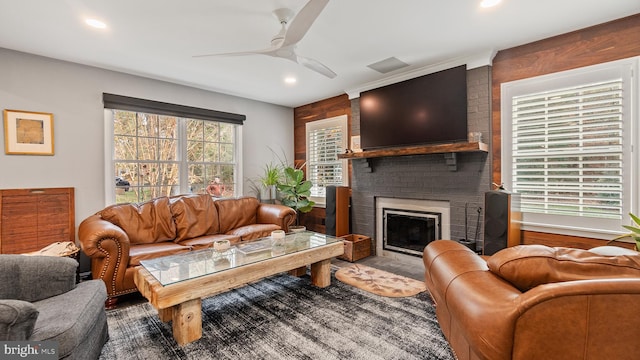 living room featuring a fireplace and ceiling fan