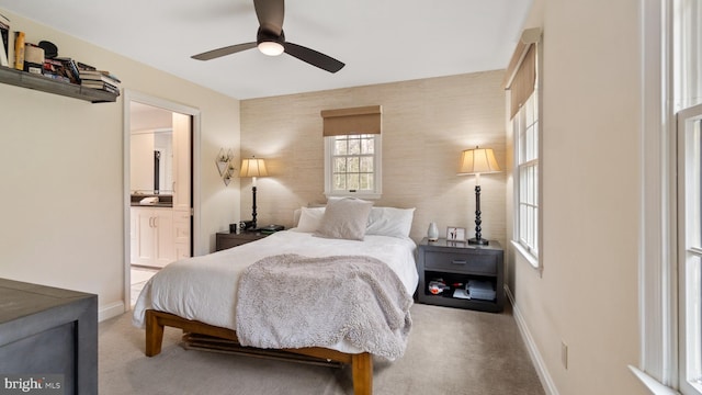 bedroom featuring connected bathroom, light colored carpet, and ceiling fan