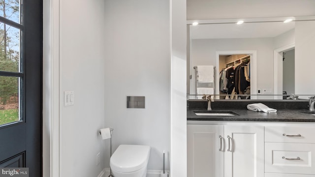 bathroom with a wealth of natural light, vanity, and toilet