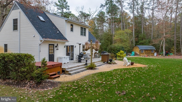 rear view of property with a lawn, a storage shed, a wooden deck, and a hot tub