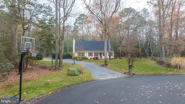 view of front of property featuring a front lawn and basketball court