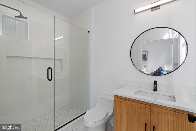 bathroom featuring vanity, toilet, and a shower with shower door