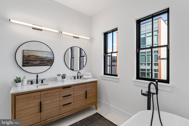 bathroom with vanity and a washtub