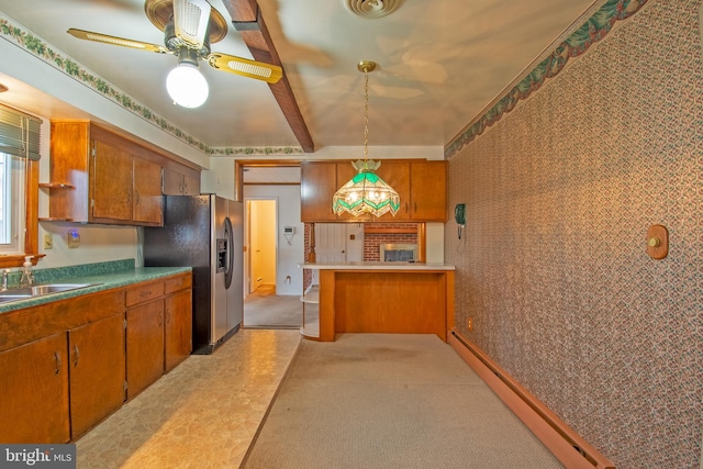 kitchen featuring kitchen peninsula, stainless steel refrigerator with ice dispenser, light colored carpet, sink, and hanging light fixtures