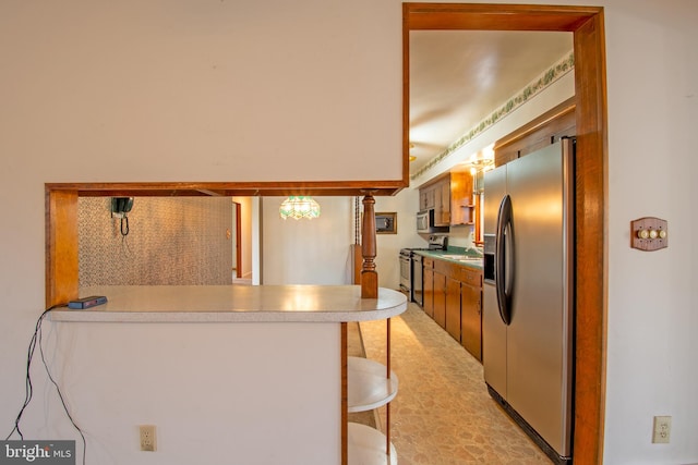 kitchen with a kitchen breakfast bar, kitchen peninsula, sink, and appliances with stainless steel finishes