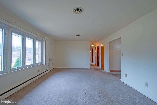 spare room featuring light carpet and a baseboard radiator