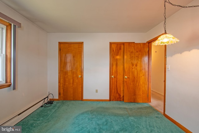 carpeted empty room with plenty of natural light and a baseboard heating unit