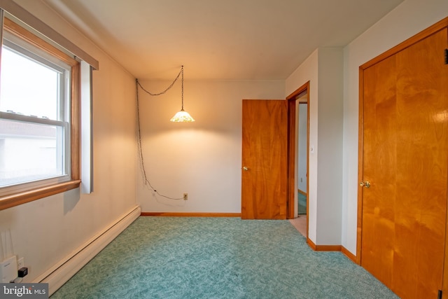 carpeted spare room featuring baseboard heating