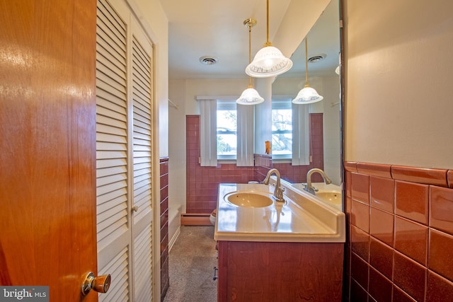 bathroom with vanity and tile walls