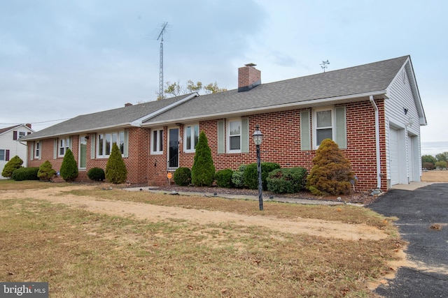 single story home featuring a garage and a front lawn