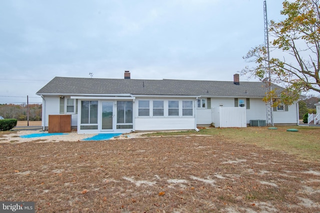 rear view of house with central AC unit and a sunroom