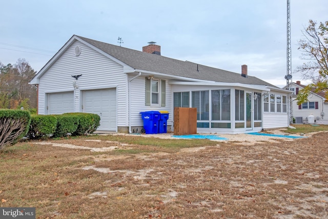 rear view of house featuring central AC, a garage, and a sunroom