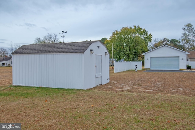 view of outdoor structure featuring a lawn and a garage