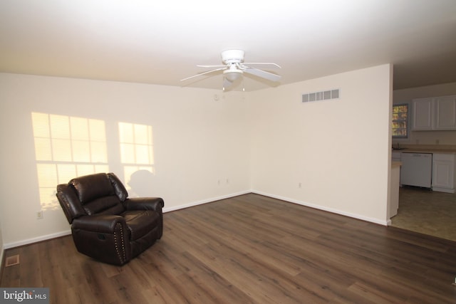 living area with ceiling fan and dark hardwood / wood-style flooring