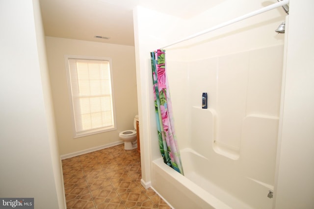 bathroom featuring tile patterned floors, toilet, and shower / tub combo