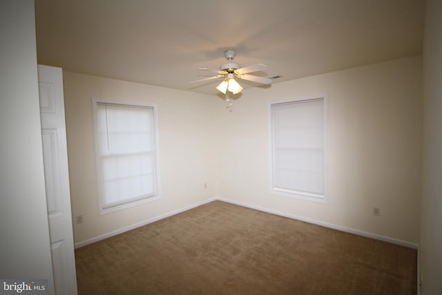 carpeted spare room with ceiling fan