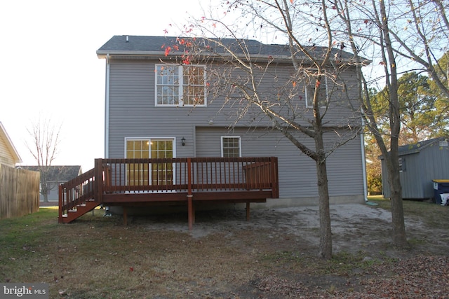 rear view of house featuring a deck and a storage unit