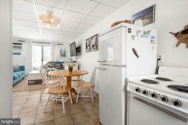 kitchen with a drop ceiling, white cabinets, and light tile patterned flooring