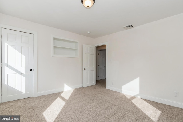 unfurnished bedroom featuring light carpet