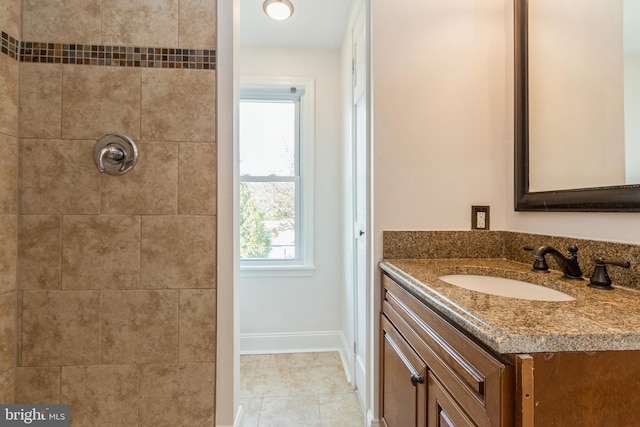 bathroom with tile patterned floors, vanity, and a tile shower