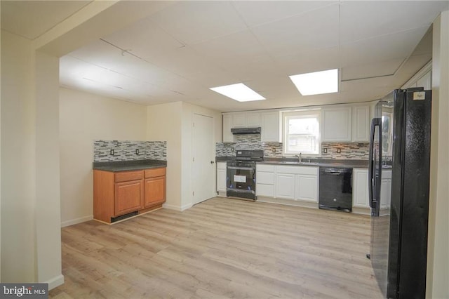 kitchen featuring white cabinetry, sink, light hardwood / wood-style flooring, decorative backsplash, and black appliances