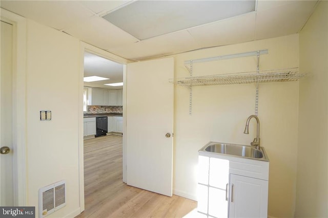 laundry room with light hardwood / wood-style floors and sink