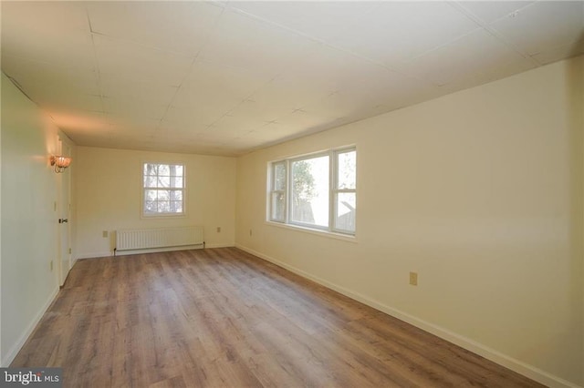 unfurnished room with light hardwood / wood-style flooring and radiator