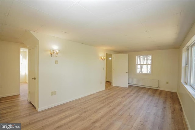 unfurnished room with light hardwood / wood-style floors and radiator